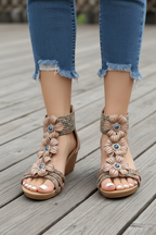 Close-up of beige flower wedge sandals on wooden deck